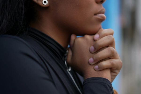 woman clasping her hands under her chin in thought